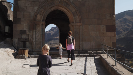 Young mother with two little blonde daughters walking in cave city vardzia © Alexander Belinskiy