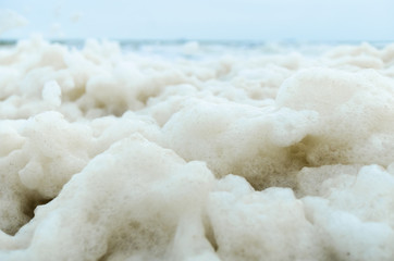 Fototapeta na wymiar Close-up abstract of a lot of sea foam on the shore. Ecology, save our planet.