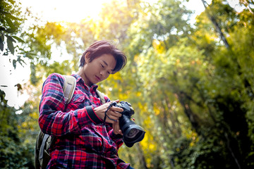 Tourists man or photographer standing and looking at camera in forest