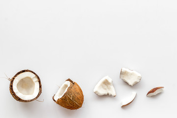 Coconuts frame - halfs and scattered pieces - on white background top-down copy space