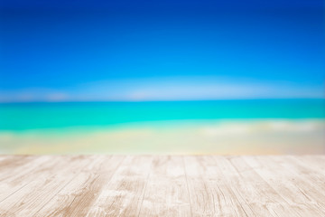 Empty wooden terrace on the beach with blurred water and sky. Close-up view with selective focus.