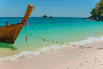 Traditional Thai longtail boat moored on exotic beach.