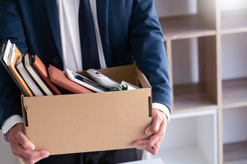 Sad Fired Young Employee businessmen hold boxes including pot plant and documents for personal belongings unemployment, resigned concept. - obrazy, fototapety, plakaty