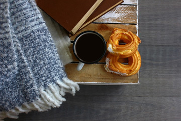 Iron mug with coffee, cream cake, two vintage books, mohair plaid, rustic wooden mini table