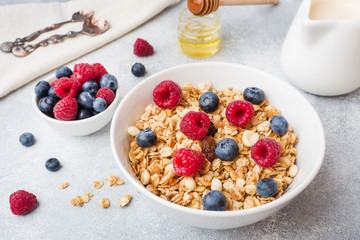 Healthy breakfast. Fresh granola, muesli with yogurt and berries on grey background. Copy space