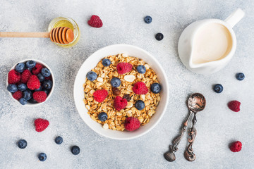 Healthy breakfast. Fresh granola, muesli with yogurt and berries on grey background. Copy space