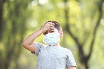 A young Asian boy , 7 Years Old , wear mask to protect against dust PM 2.5 and germs