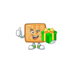 Cheerful crackers cartoon character holding a gift box
