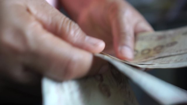 Weak baht, Thai baht banknotes, Businessman's hands counting money. one thousand baht. (THB) is official currency of Thailand. Finance and banking business in Asia, impact of global economy from virus
