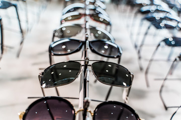 Fototapeta na wymiar Sunglasses in a store. Row of luxury eyeglass at an opticians store