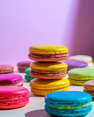 Beautiful macaroons lie on a colored background on a sunny day