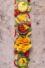 Mexican food background: guacamole, salsa, cheesy sauces with nachos