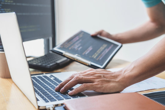 Young Professional programmer working at developing programming and website working in a software develop company office, writing codes and typing data code, Programming with HTML, PHP and javascript