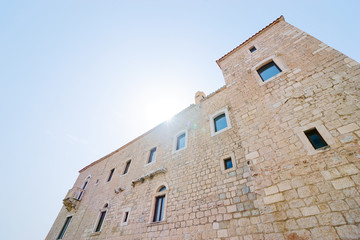 Travel and tourism. Big ancient castle wall against sunny sky.