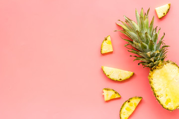 Pineapple - half of fruit and slices - on pink background top-down copy space