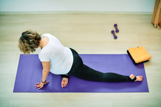 Mid-adult fit pregnan Caucasian woman practicing yoga. Morning time.	