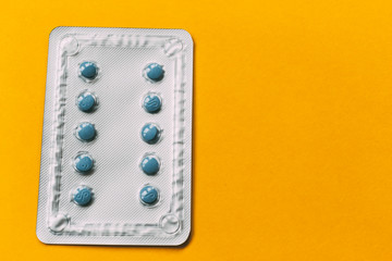 blue medicine blister pack on yellow background