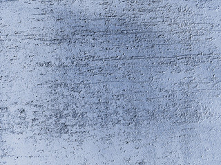 Cracked wall surface covered by decorative plaster. Painted into dark blue. Decorative construction materials and colours. Abstract background texture pattern with copyspace
