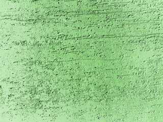 Concrete wall surface covered with decorative stucco and painted into light green color. Decorative materials. Background texture