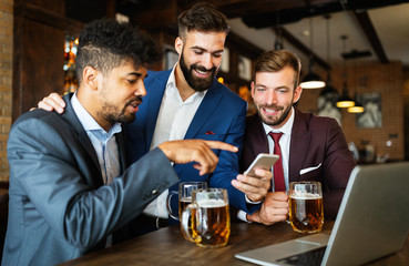 Business people drink beer after work. Businessmen enjoy a beer.