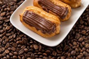 custard cakes with chocolate icing on coffee beans