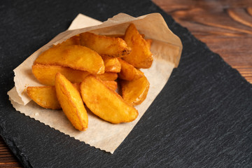 Potato rustic tableware slate, black stone on a wooden background.