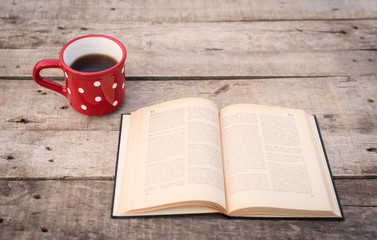 Old book with tea on a wooden table