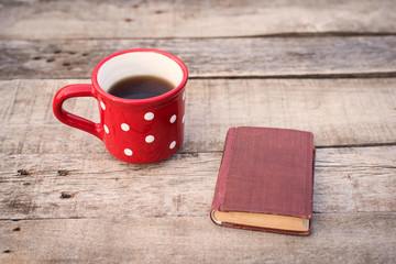 Old book with tea on a wooden table