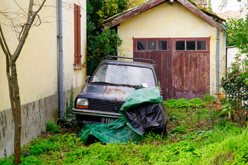 old vehicle abandoned car and wreck mess on the garden old house