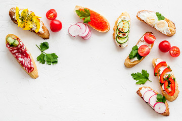 Sandwiches - set with vegetables, caviar, salami - on white background top-down copy space
