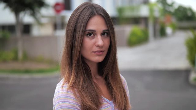 Portrait brunette embarrassed lowers eyesand straightens her hair. 4k