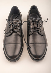 A pair of black leather boots on a white background. Close up.