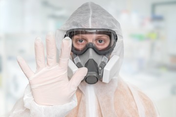 Scientist with FFP3 respirator mask is showing STOP gesture - obrazy, fototapety, plakaty