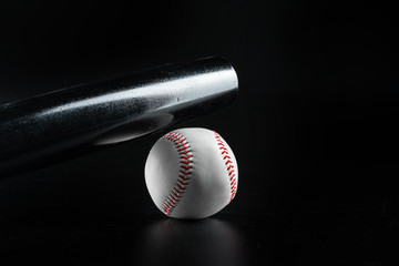Baseball game equipment on dark black background close up