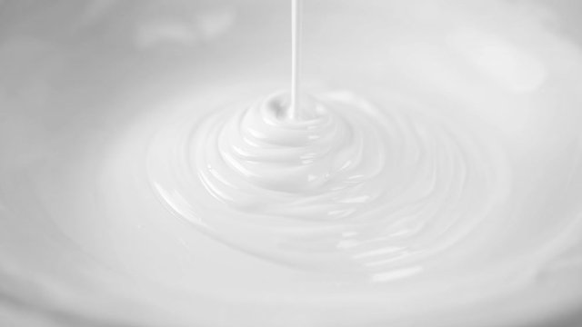 Slow motion of white cream or body lotion drop on skin care background with abstract wave.
