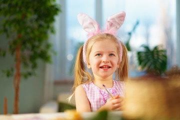 Easter concept. Toddler blonde happy  girl with bunny ears