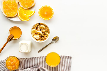 Vegetarian breakfast with granola and fruits on white background top-down frame copy space