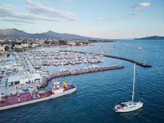 Aerial drone bird's eye view of famous and picturesque port of Aegina island with fishing boats docked and Yachts, Saronic gulf, Greece