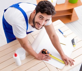 Worker working on wallpaper during refurbishment