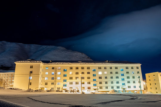 Cloudy sky over a mountain town with night lights.
