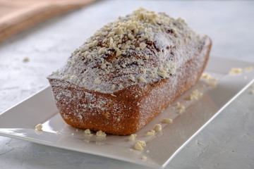 Tasty and fragrant cupcake with strawberries and almonds with a crispy crust on a white plate