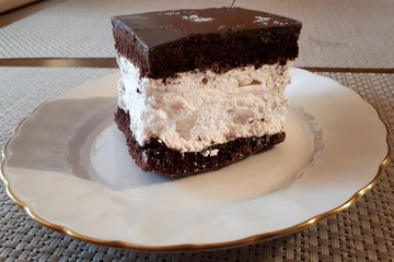 Cocoa cake with cream on plate.