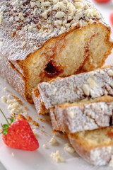 Tasty and fragrant cupcake with strawberries and almonds with a crispy crust on a white plate