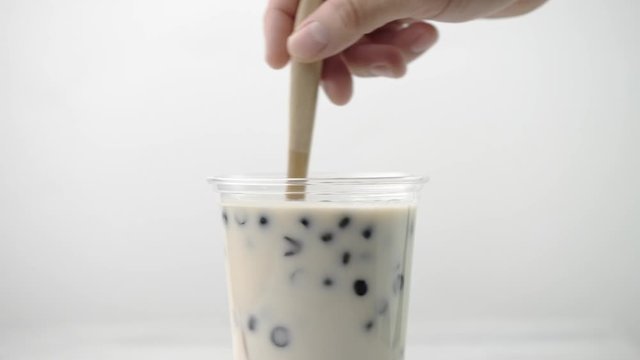 Taiwanese popular drink, Tapioca pearl bubble milk tea in glass cup on white  table background 4K shot video