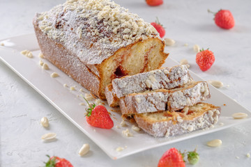 Tasty and fragrant cupcake with strawberries and almonds with a crispy crust on a white plate