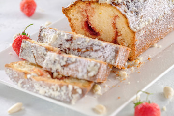 Tasty and fragrant cupcake with strawberries and almonds with a crispy crust on a white plate
