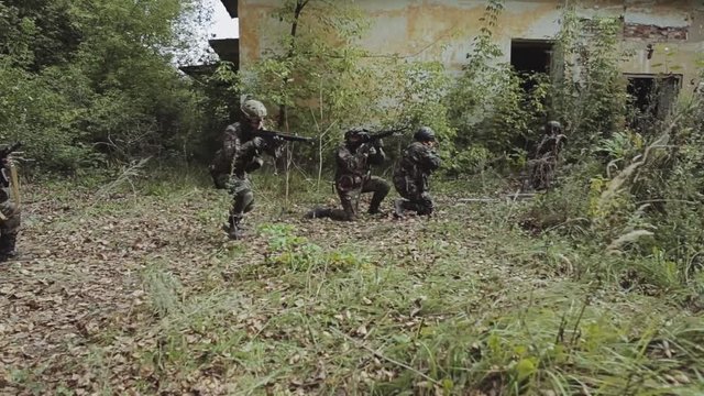 Five special forces soldiers are approaching the old factory. The squad is preparing for an assault. The work of a special -purpose unit. Terrorist threat