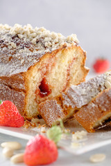 Tasty and fragrant cupcake with strawberries and almonds with a crispy crust on a white plate