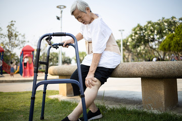 Tired asian senior woman with leg,knee pain,touch her knee pain,female elderly with acute knee...