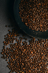 Vertical top view of roast coffee pan and beans on ardesia table